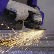 Craftsman sawing metal with disk grinder in workshop. Craftsman sawing metal with disk grinder in workshop.